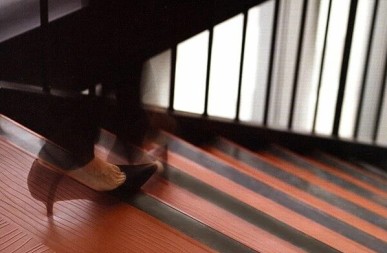 A woman is walking down a set of stairs with anti-slip floor mats.