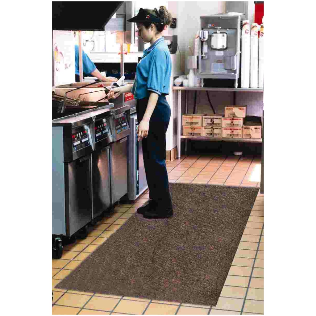 A woman is standing on a Grip Rock Floor Mat in a kitchen.